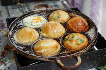 The process of making quail egg mini martabak. one of the street food in Indonesia. This snack consists of flour dough, sliced ​​scallions. Cooked in a frying pan with a small round pattern.
