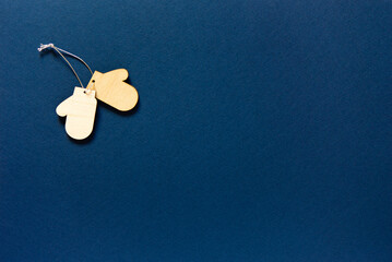 Minimalist Christmas decoration on blue background.  wooden Christmas decorations - mittens.