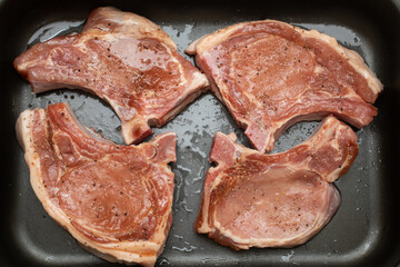 Raw tomahawk steaks on an oven tray