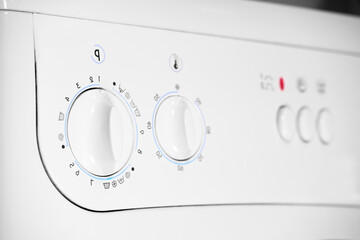 Close up of temperature control and program knobs on white washing machine