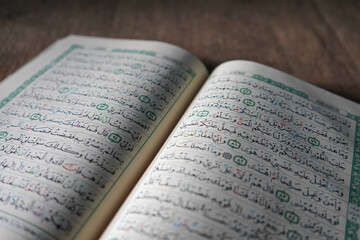 Fototapeta premium Kudus, Indonesia - August, 2022 : The Quran, also romanized Qur'an or Koran, is the central religious text of Islam, believed by Muslims to be a revelation from God (Allah). Brown sack background.