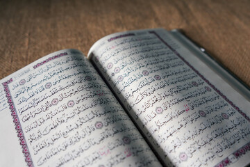Fototapeta premium Kudus, Indonesia - August, 2022 : The Quran, also romanized Qur'an or Koran, is the central religious text of Islam, believed by Muslims to be a revelation from God (Allah). Brown sack background.