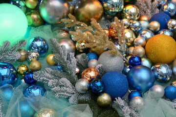 Christmas decoration: lots of blue, gold and silver balls lie next to the spruce branches. Traditional New Year's decor,winter holiday at home.