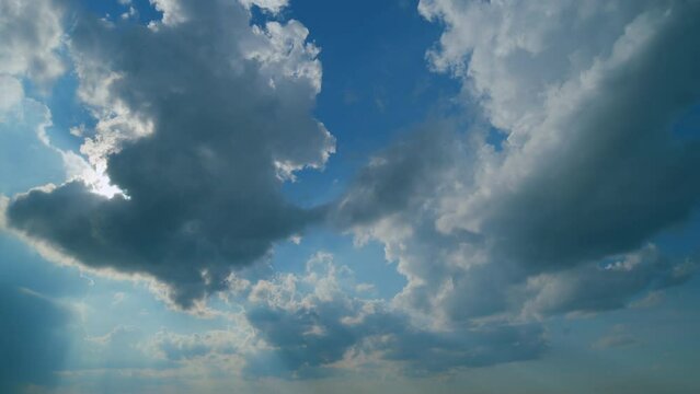 Building clouds and sun rays breaking through cloud mass. Flares shinning through dramatic clouds. Time lapse.
