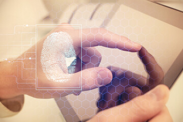 Double exposure of man's hands holding and using a digital device and fingerprint hologram drawing. Security concept.