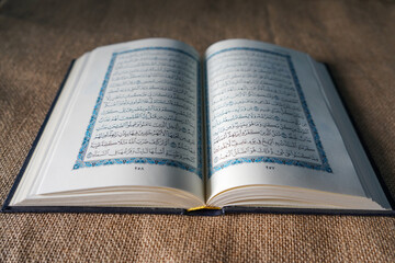 Indonesia - July, 2022 : The Quran, also romanized Qur'an or Koran, is central religious text of Islam, believed by Muslims to revelation from God (Allah). Classical Arabic. Sack, Blue.  white. Open.