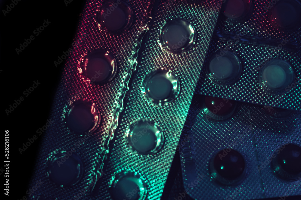 Poster pills or drugs in a package under neon light on a dark background pattern for design..