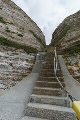 Fototapeta na wymiar Stairway up from the beach Plage du Fourquet at the cliffs of the Alabaster coast, Etretat, Normandy, France
