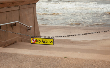 No Access Sign Dangling At Top Of Steps Leading Down To Beach