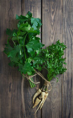 Fresh celery, parsley, basil and dill on a wooden background. Top view. Flat lay. Greens for salads and vitamin drinks.