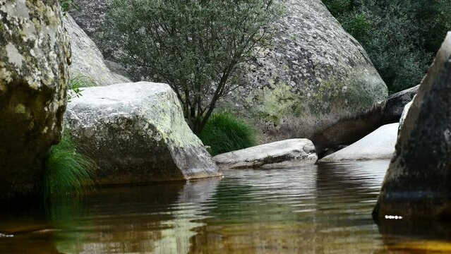 Detalle de un r&iacute;o con piedras y rocas que provoca paz y tranquilidad. La Pedriza, Madrid, Espa&ntilde;a.