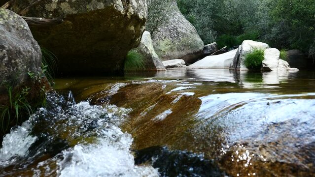 Detalle de un r&iacute;o con piedras y rocas que provoca paz y tranquilidad. La Pedriza, Madrid, Espa&ntilde;a.