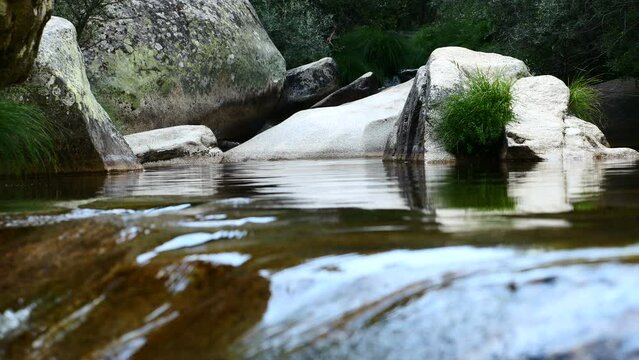Detalle de un r&iacute;o con piedras y rocas que provoca paz y tranquilidad. La Pedriza, Madrid, Espa&ntilde;a.