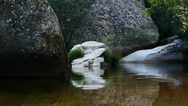 Detalle de un r&iacute;o con piedras y rocas que provoca paz y tranquilidad. La Pedriza, Madrid, Espa&ntilde;a.