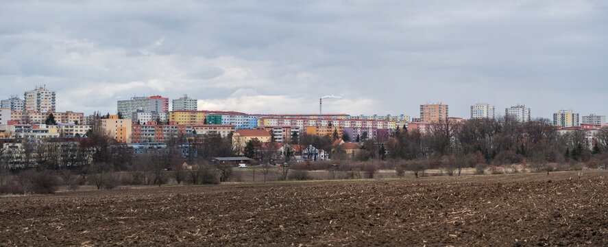 Chodov, Prague, Czech Republic, March 13, 2021: Panoramic view of Housing Estate Chodov with prefabricated buildings or block of flats constructed with panels over the bare field. Cloudy spring day