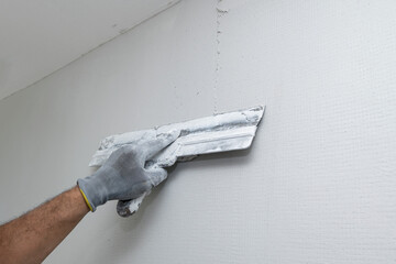 Plasterer applies plaster on the wall during repair and restoration work