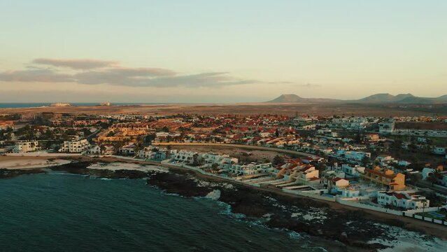 Canary islands, Spain. Resort town. Travel addict. Paradise touristic spot. Sunset. Ocean shore. Corralejo aerial cityscape, port city in Fuerteventura, beautiful view of streets and buildings.