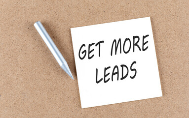 GET MORE LEADS text on sticky note on a cork board with pencil ,