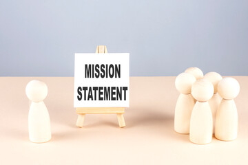 MISSION STATEMENT text on easel with wooden figure, meeting concept