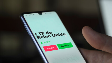 Un inversor está analizando el reino unido etf fondo en pantalla. Un teléfono muestra los precios del ETF REINO UNIDO para invertir.