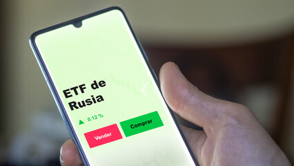 Un inversor está analizando el rusia etf fondo en pantalla. Un teléfono muestra los precios del ETF RUSIA para invertir.