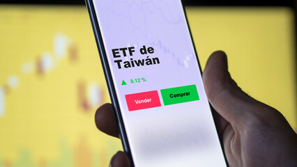 Un inversor está analizando el taiwán etf fondo en pantalla. Un teléfono muestra los precios del...