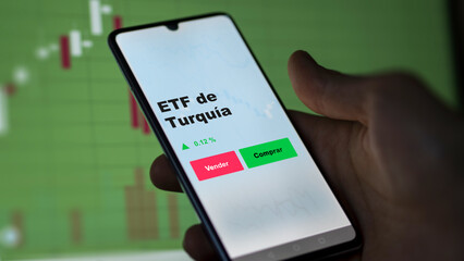Un inversor está analizando el turquía etf fondo en pantalla. Un teléfono muestra los precios del ETF TURQUÍA para invertir.