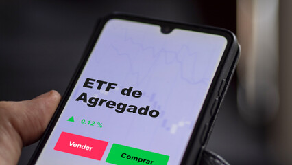 Un inversor está analizando el agregado etf fondo en pantalla. Un teléfono muestra los precios del ETF para invertir.