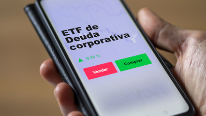 Un inversor está analizando el deuda corporativa etf fondo en pantalla. Un teléfono muestra los precios del ETF para invertir.