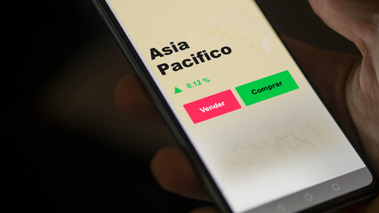 Un inversor está analizando el asia pacifico etf fondo en pantalla. Un teléfono muestra los precios del ETF ASIA PACIFICO para invertir.