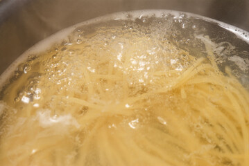 Cooking spaghetti in a pot of boiling water