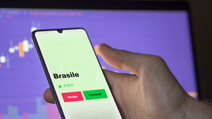 Un inversor está analizando el brasile etf fondo en pantalla. Un teléfono muestra los precios del ETF BRASILE para invertir.