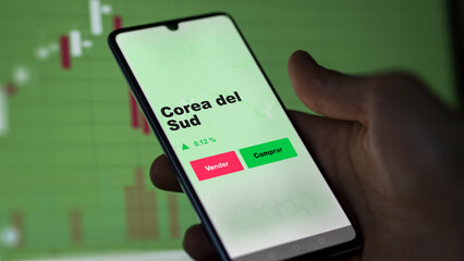 Un inversor está analizando el corea del sud etf fondo en pantalla. Un teléfono muestra los...