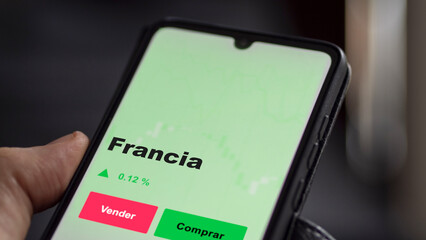Un inversor está analizando el francia etf fondo en pantalla. Un teléfono muestra los precios del ETF FRANCIA para invertir.
