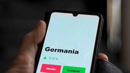 Un inversor está analizando el germania etf fondo en pantalla. Un teléfono muestra los precios del ETF GERMANIA para invertir.