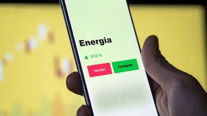 Un inversor está analizando el energia etf fondo en pantalla. Un teléfono muestra los precios del ETF para invertir. © maurice norbert