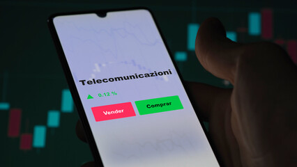 Un inversor está analizando el telecomunicazioni etf fondo en pantalla. Un teléfono muestra los...