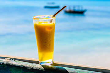 Juice of pineapple and orange. Ocean at the background