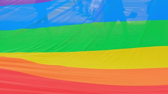 Big rainbow flag waving in slow motion during LGBT pride. 