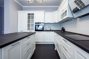 Fashionable kitchen with grey walls and white furniture, a kitchen in a modern classic style with granite countertop and bar island