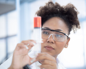 Scientist, chemist woman working in medical research laboratory experimenting chemistry liquid in beaker tube. African American student doctor studying, analyzing sample chemical in pharmaceutical lab