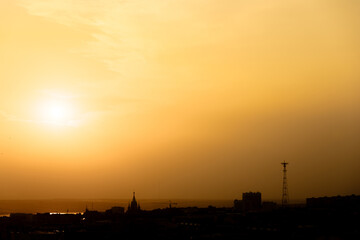 Orange sunset over dark city skyline