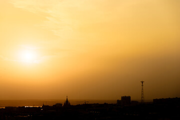 Naklejka premium Orange sunset over dark city skyline
