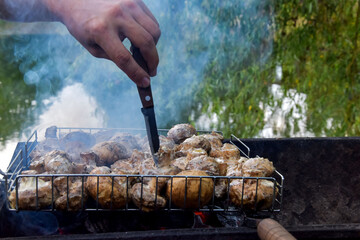 Pickled mushrooms, champignons are fried on the grill. Light tasty smoke rises above the grill...