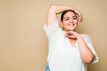 Beautiful plus size woman posing in front of a studio background