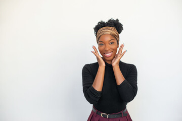 Portrait of pleased African American woman. Female model in black long sleeve shirt and trousers against white background, looking at camera, smiling. Portrait, beauty, studio photoshoot concept