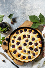 Homemade blackberry pie. Vegan gluten-free pastry. Sweet pie with blackberry and custard on stone tabletop. View from above. Copy space.
