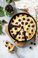 Homemade blackberry pie. Vegan gluten-free pastry. Sweet pie with blackberry and custard on stone tabletop. View from above.