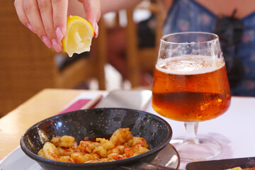 fried shrimps with lemon slice, garlic sauce aioli and tomato ketchup frying pan close up photo...