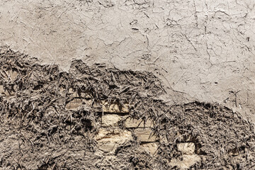 Uneven brick wall covered with clay and straw adobe, Bukhara, Uzbekistan